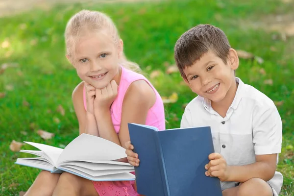 Милые маленькие дети читают книги на открытом воздухе — стоковое фото