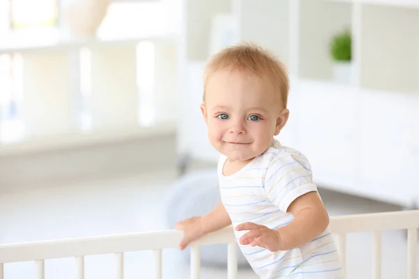 Söt liten bebis i barnsäng hemma — Stockfoto