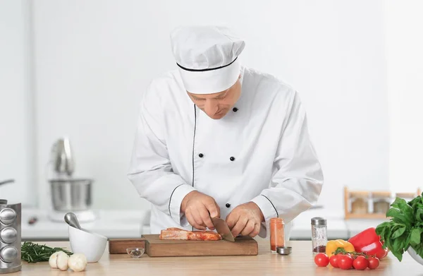 Manliga chef styckning av kött i köket — Stockfoto