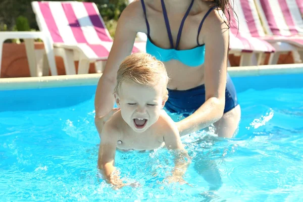 Mor ger baby bad lektion i pool — Stockfoto
