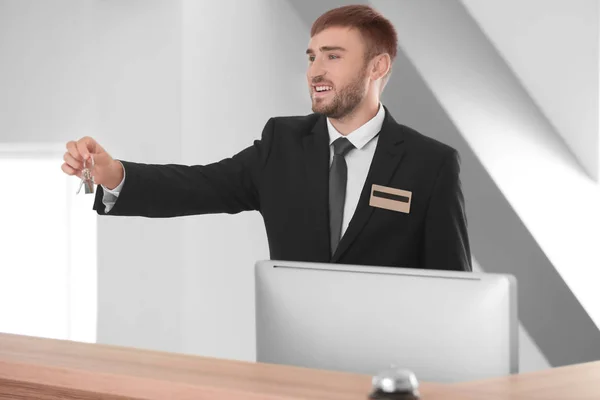 Manlig receptionist med rumsnyckel i hotel — Stockfoto