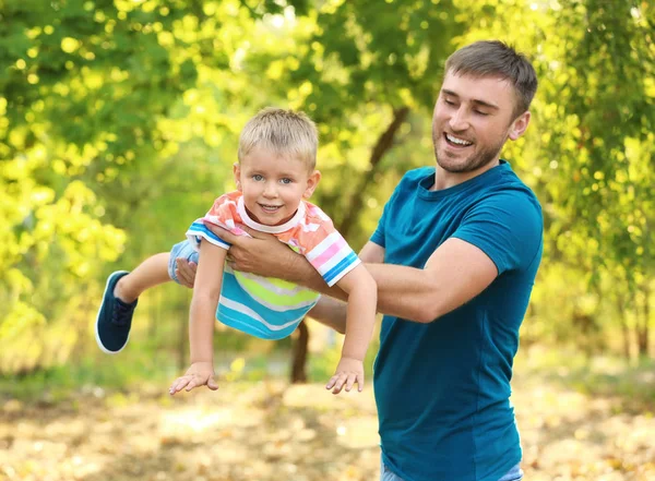 Homem feliz com filho no parque no dia ensolarado — Fotografia de Stock