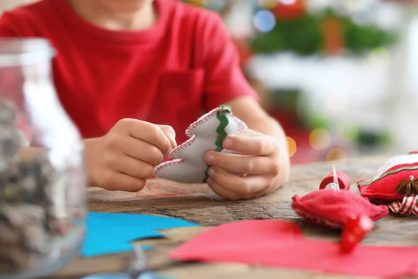 Child making felt Christmas fir tree at table — Stock Photo, Image