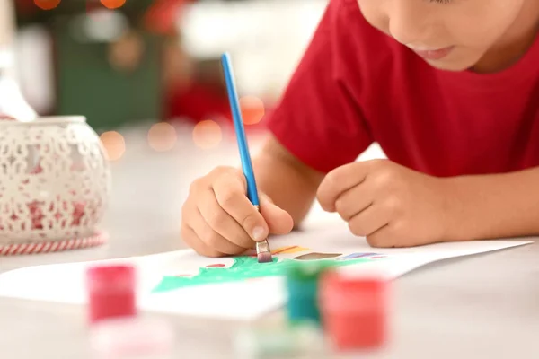 Leuke jongen schilderij fir kerstboom op vloer, close-up — Stockfoto