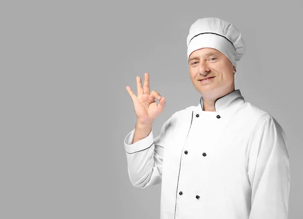 Чоловічий шеф-кухар у формі на сірому фоні — стокове фото