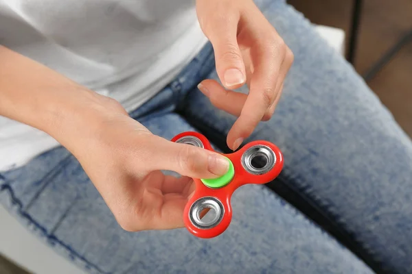 Vrouw rollende moderne spinner binnenshuis — Stockfoto