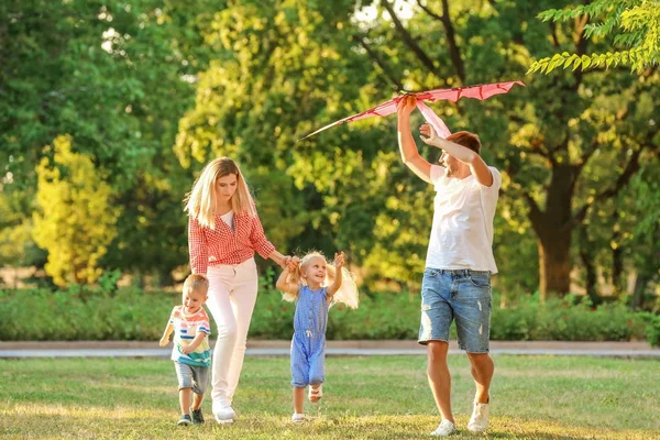 Familia feliz jugando con cometa en el parque en el día soleado — Foto de Stock