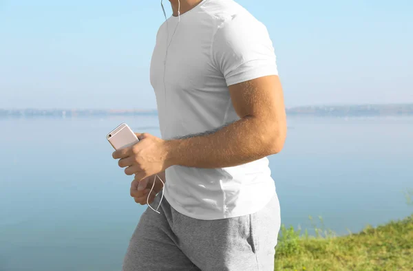 Handsome sporty man running outdoors — Stock Photo, Image