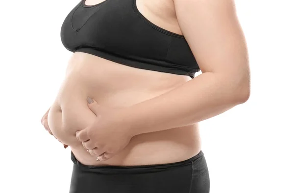 Mujer tocando grasa en su vientre contra fondo blanco. Concepto de pérdida de peso — Foto de Stock