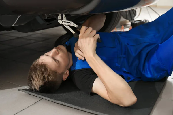 Junger Mechaniker repariert Auto in Karosseriebau — Stockfoto