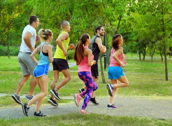 Sportig ungdomar kör i grön park — Stockfoto