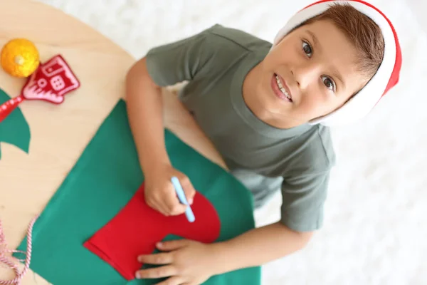 Netter Junge bastelt Weihnachtssocke aus Filz auf dem Tisch — Stockfoto