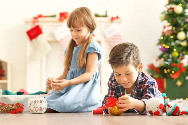 Enfants mignons faisant de l'artisanat de Noël sur le sol — Photo
