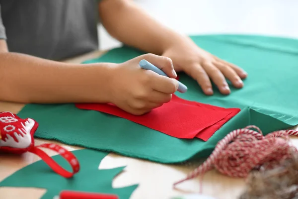 Cute boy making Christmas sock from felt on table — Stock Photo, Image