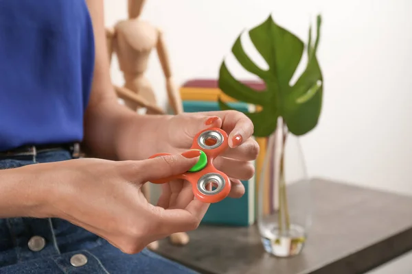 Vrouw rollende moderne spinner binnenshuis — Stockfoto