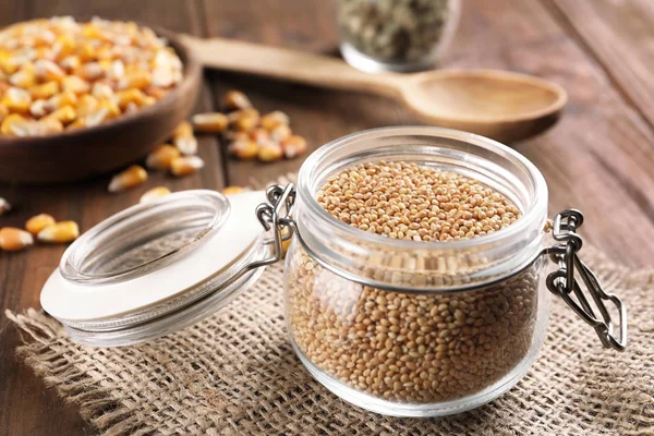 Jar with wheat grains on table — Stock Photo, Image