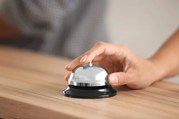 Woman ringing service bell at hotel reception — Stock Photo, Image
