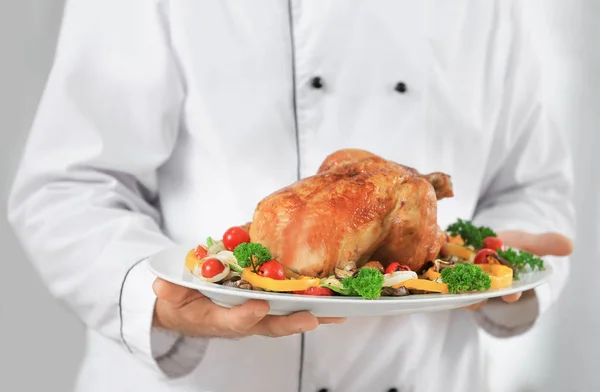 Chef holding plate with cooked chicken — Stock Photo, Image