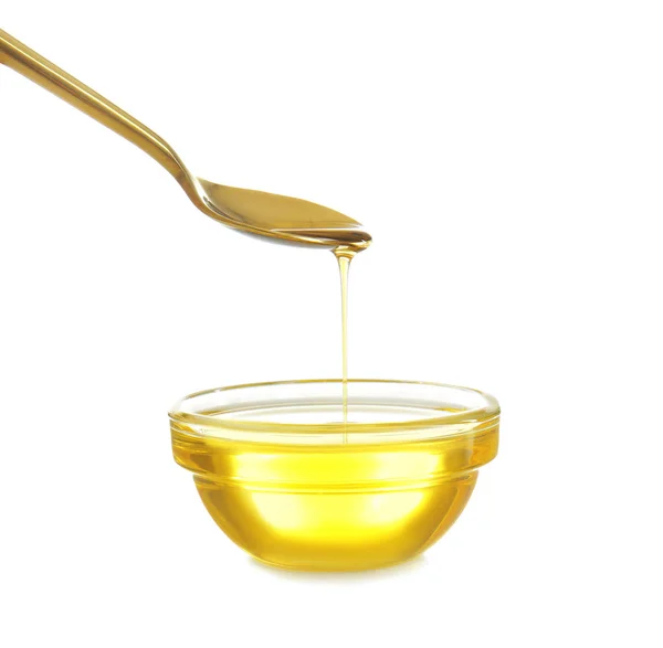 Cooking oil pouring from spoon into glass bowl on white background — Stock Image Cooking oil pouring from spoon into glass bowl — Stock Photo, Image