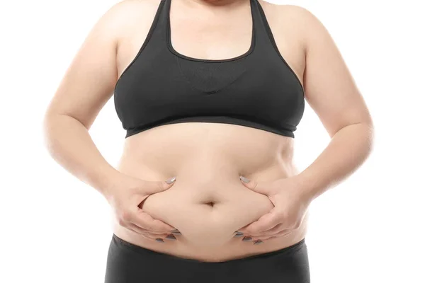 Mujer tocando grasa en su vientre contra fondo blanco. Concepto de pérdida de peso —  Fotos de Stock