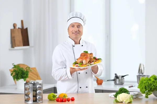 Chef masculino segurando prato com frango cozido e legumes na cozinha — Fotografia de Stock