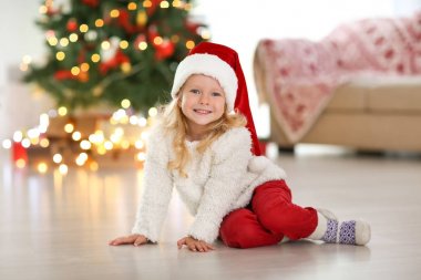 Sevimli küçük kız evde katta oturan Noel şapkalı