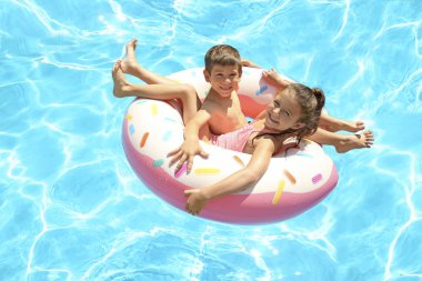 Yüzme havuzunda şişme halkası üzerinde şirin çocuk