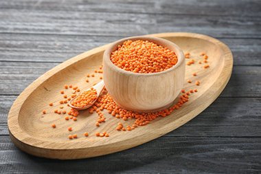 Kase ve kaşık ahşap tepsi üzerinde kırmızı mercimek ile