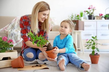 Sevimli küçük kız anne alarak bakım kapalı bitkiler ile