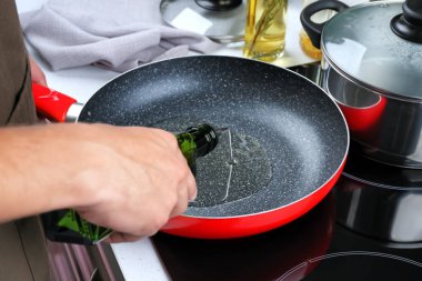 Yemeklik yağ şişe kızartma tavası dökülen adam