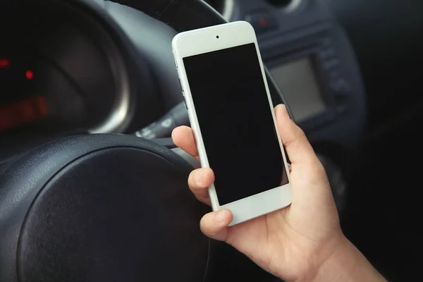 Жінка тримає мобільний телефон в машині — стокове фото
