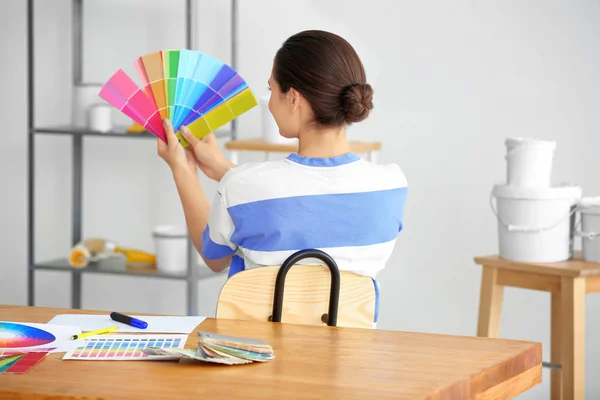 Decoração feminina segurando amostras de paleta de cores no escritório — Fotografia de Stock