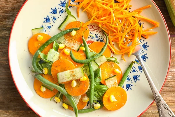 Plato con sabrosa ensalada de zanahoria en la mesa —  Fotos de Stock