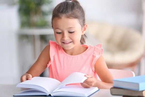 Мила маленька дівчинка читає книгу — стокове фото