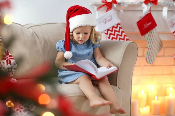 Menina Bonito Chapéu Natal Leitura Livro Casa — Fotografia de Stock