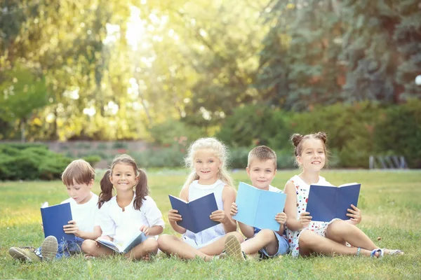 귀여운 어린 아이 들을 공원에서 책을 읽고 — 스톡 사진