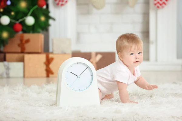 Αξιολάτρευτο μωρό με το ρολόι στο διακοσμημένο δωμάτιο. Έννοια αντίστροφη μέτρηση Χριστουγέννων — Φωτογραφία Αρχείου