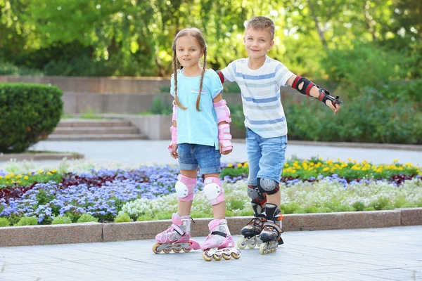 Ragazzo attivo e ragazza pattinaggio nel parco — Foto Stock