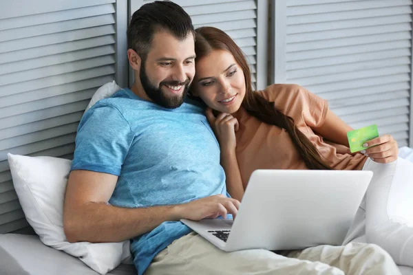 Jeune couple avec ordinateur portable à la maison. Concept de magasinage Internet — Photo