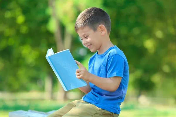 公園でかわいい少年読書本 — ストック写真