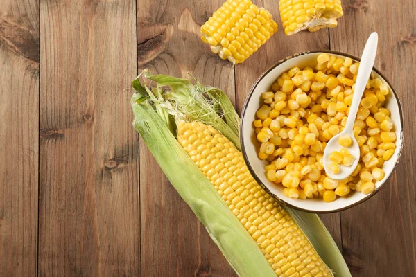 Mazorca de maíz y granos en un tazón — Foto de Stock