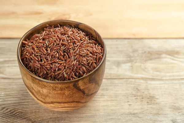 Tigela com arroz cru na mesa de madeira — Fotografia de Stock