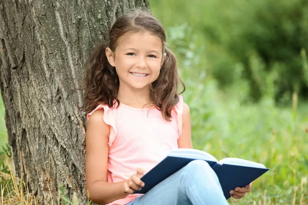 Söt liten flicka läser bok — Stockfoto