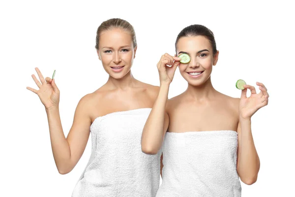 Young women with cucumber slices on white background — Stock Photo, Image