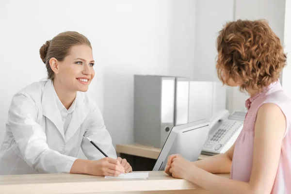 Joven recepcionista femenina con cliente en el hospital —  Fotos de Stock