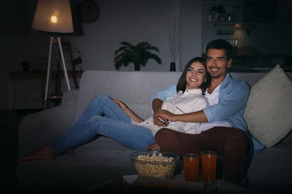 Giovane coppia guardando la TV sul divano di notte — Foto Stock