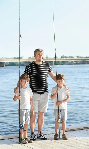 Молодой отец с сыновьями на пирсе — стоковое фото