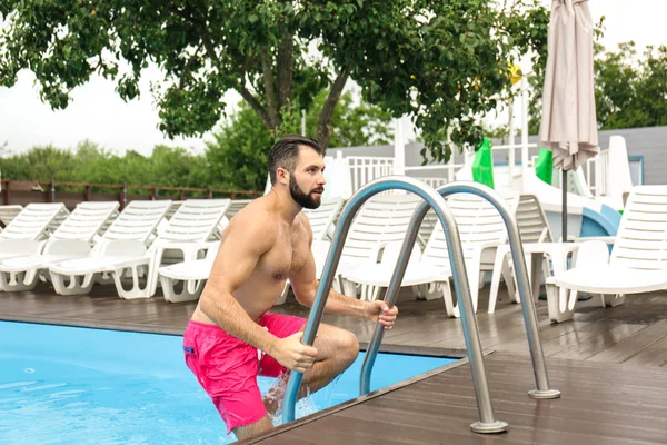 Mann steigt aus Schwimmbad — Stockfoto