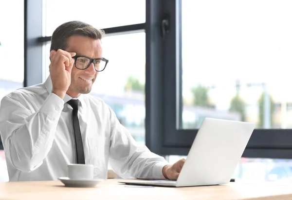 Jeune homme d'affaires utilisant un ordinateur portable sur le lieu de travail — Photo