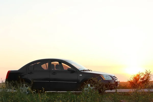 Moderní auto proti západu slunce — Stock fotografie